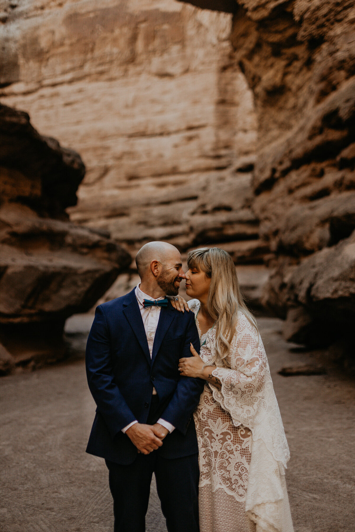 bride and groom standing together in a slot canyon