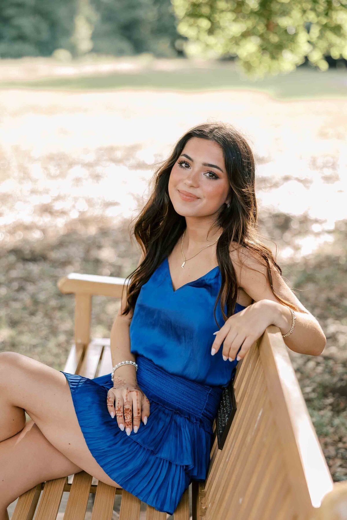 Brunette girl wearing a royal blue dress with her hands on her hips