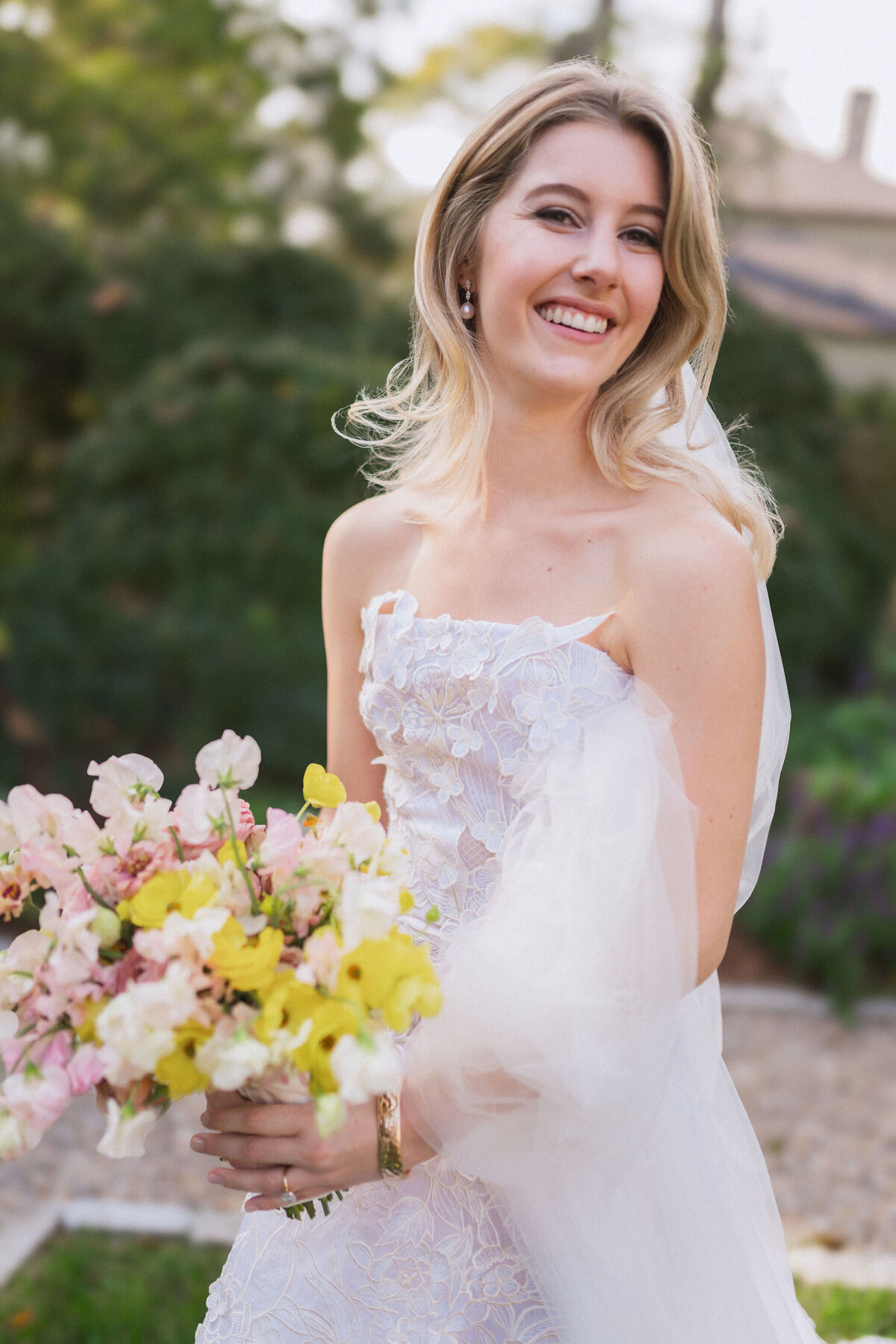 Product clustered bridal bouquet with sweet peas, local zinnias, and butterfly ranunculus. Elegant and simple bridal bouquet and bridal party bouquets with hues of blush and pops of yellow. Unique fall wedding design for private residence wedding in Nashville, TN. Bridal party wearing brown and wedding design with touches of brown. Design by Rosemary & Finch Floral Design in Nashville, TN.