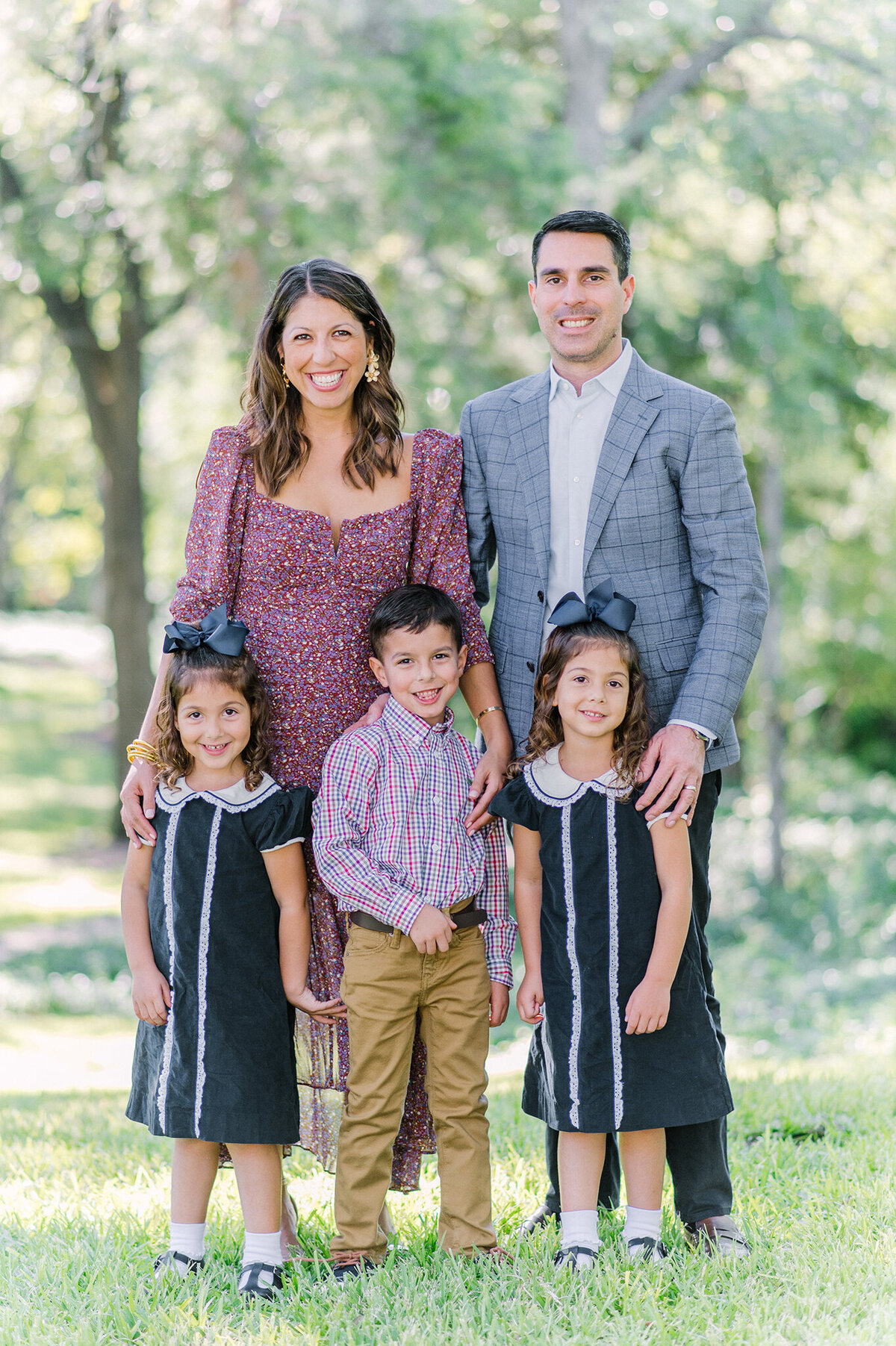 Family of five wearing high-end clothing in a Highland Park , Texas park.