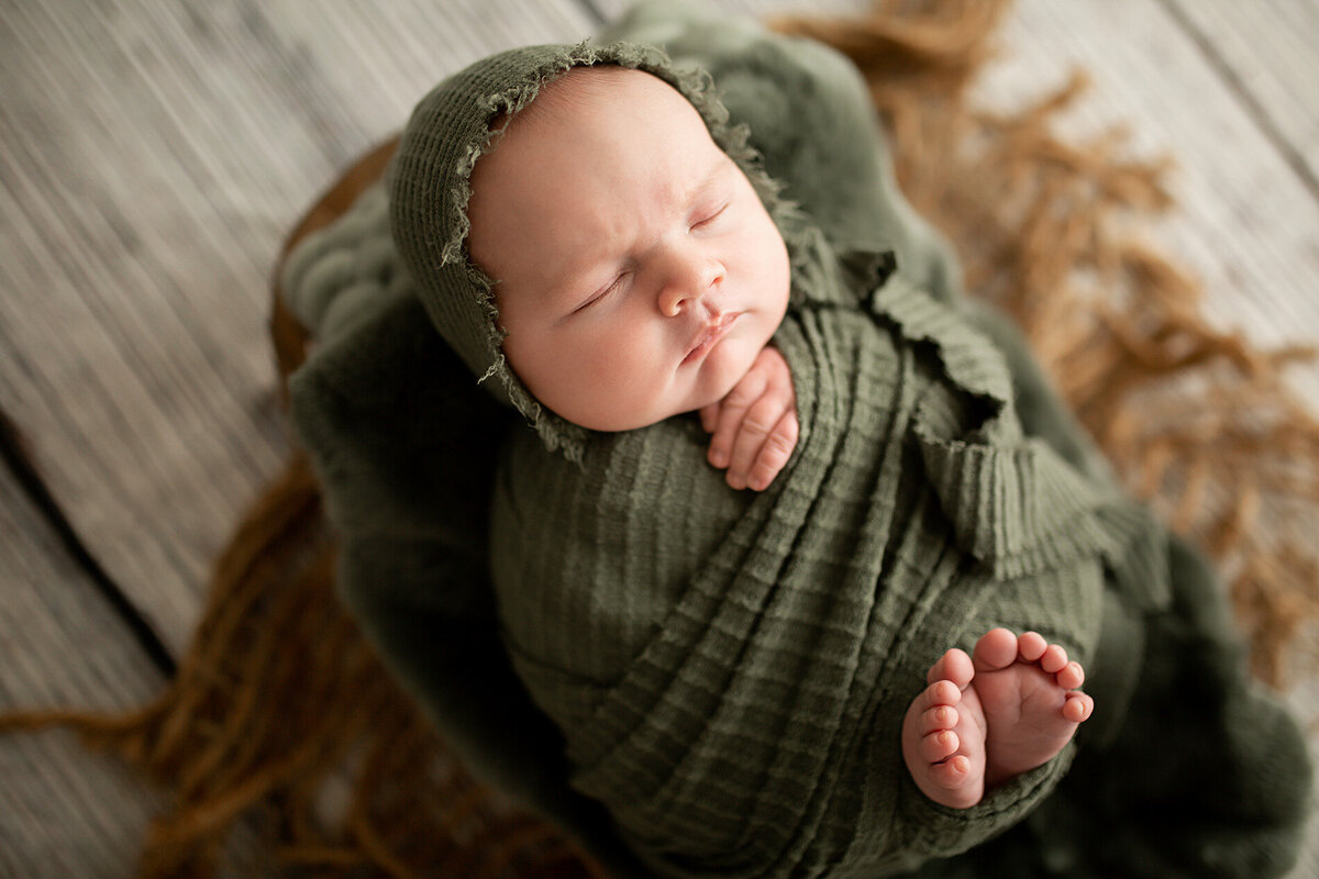 newborn baby boy in green swaddle