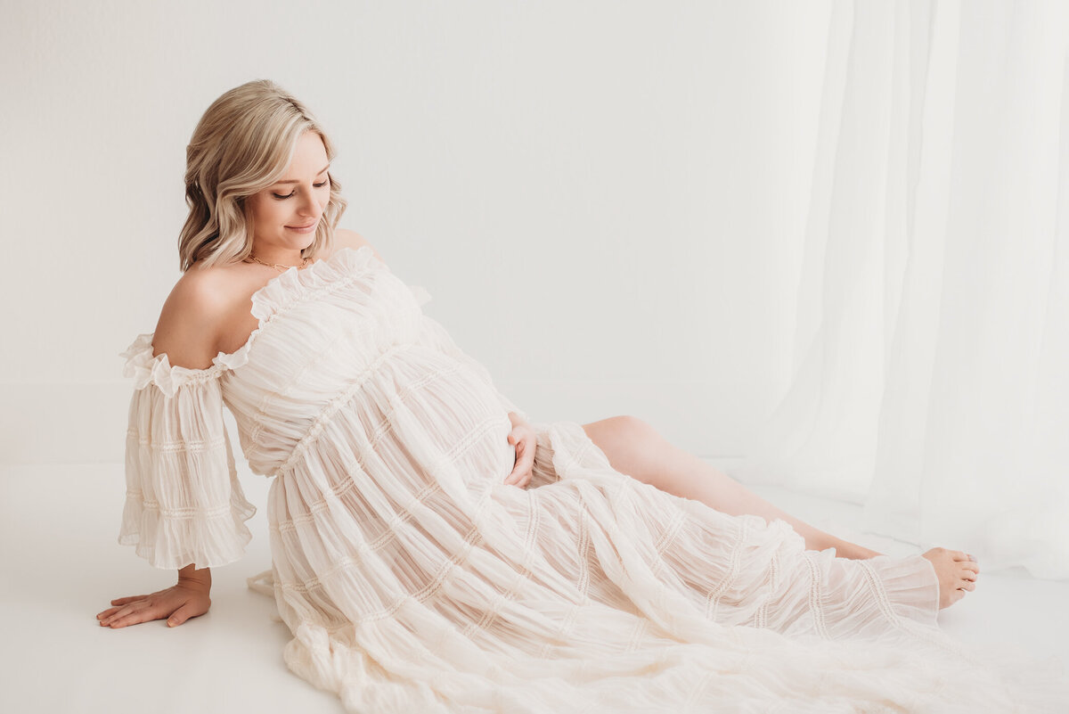 denver maternity photographer with pregnant woman in white studio