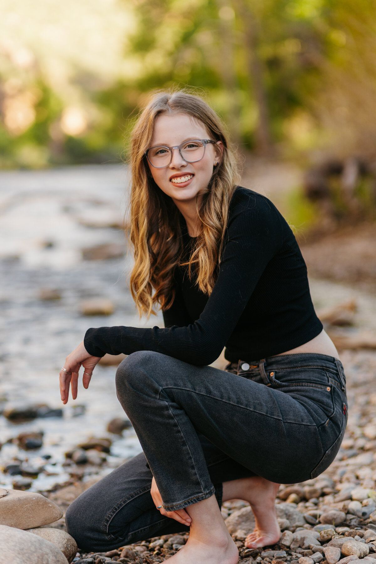 A senior poses for a photo during her senior session at Watson Lake in Bellvue, Colorado.