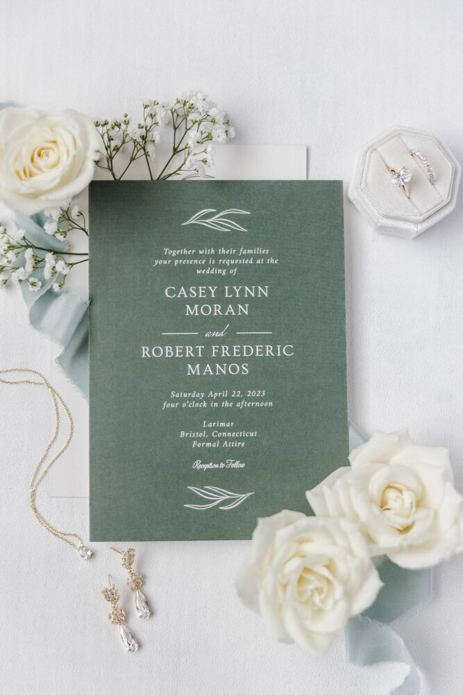 flat lay of a green wedding invitation