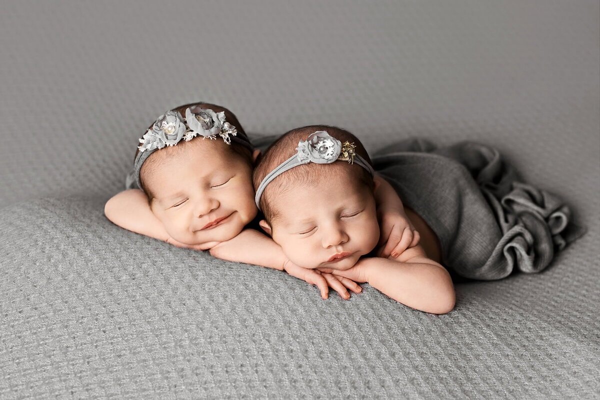 mobile-in-home-newborn-photography-vancouver-fraser-valley_newborn-twins-baby-girls-smiling-grey-blanket