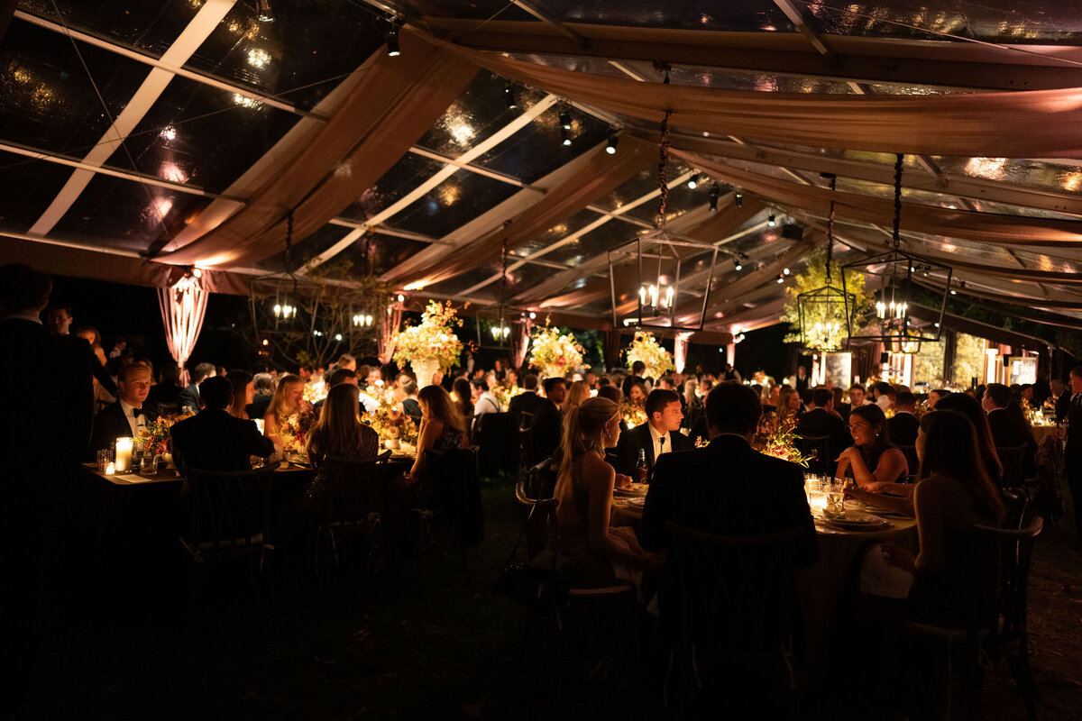Tastefully designed fall wedding in Nashville, TN. Wedding colors with touches of brown, copper, and chartreuse. Romantic candlelight dinner. Custom wedding reception linens with Oscar De La Renta material. Fall florals with sweet peas, dahlias, butterfly ranunculus, roses, mums, and bittersweet berries. Clear tented wedding at private residence. Design by Rosemary & Finch Floral Design in Nashville, TN.