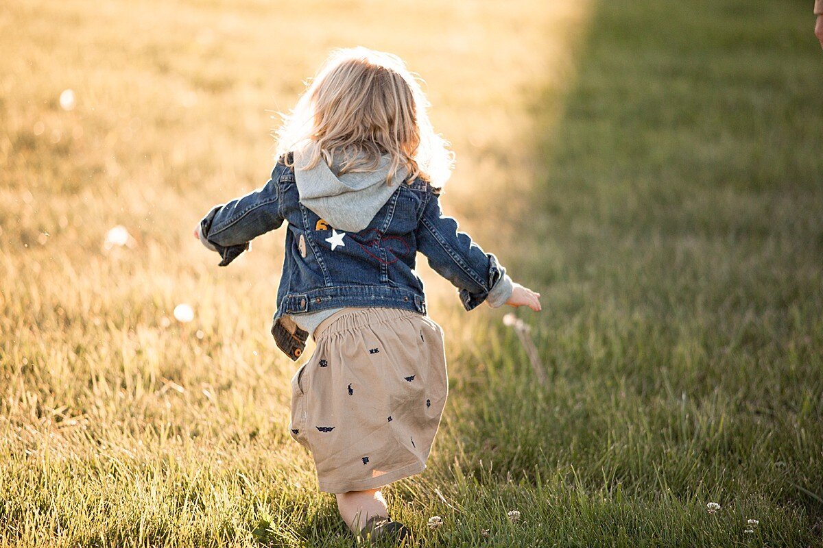Toddler girl running in the grass