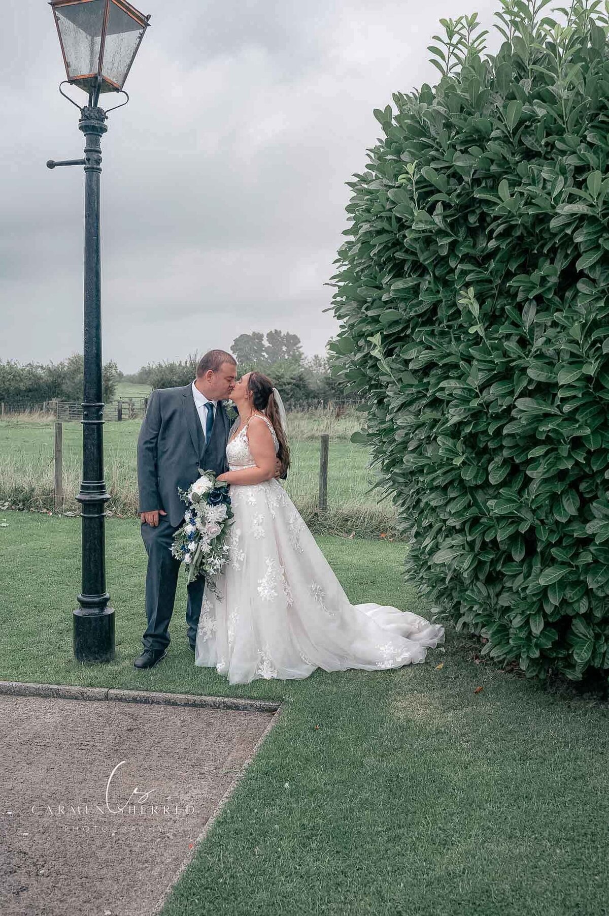 Bride and groom sharing a kiss under a lampost - Lancanshire Wedding Photography