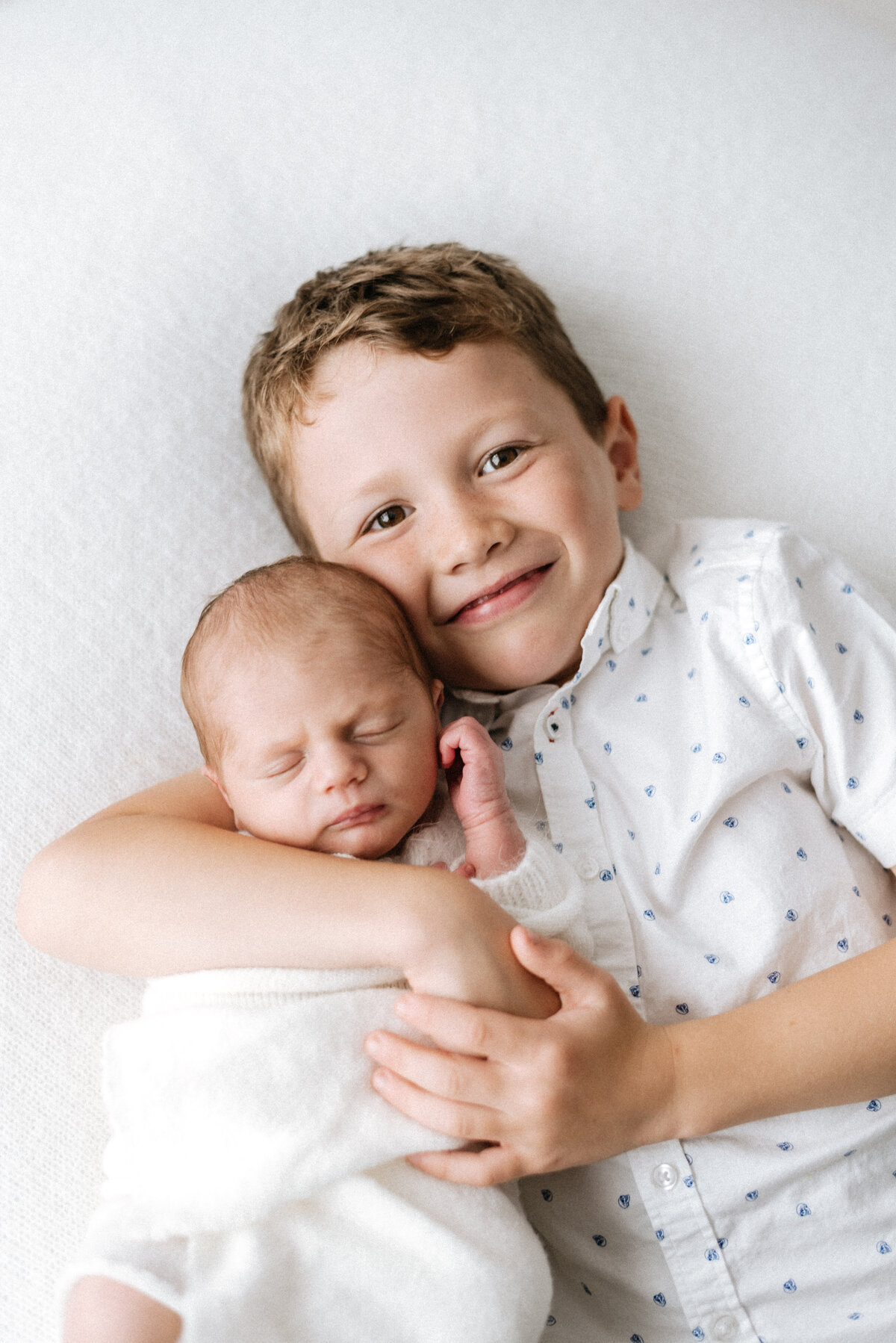 Big brother holding baby sister at billingshurst newborn photoshoot