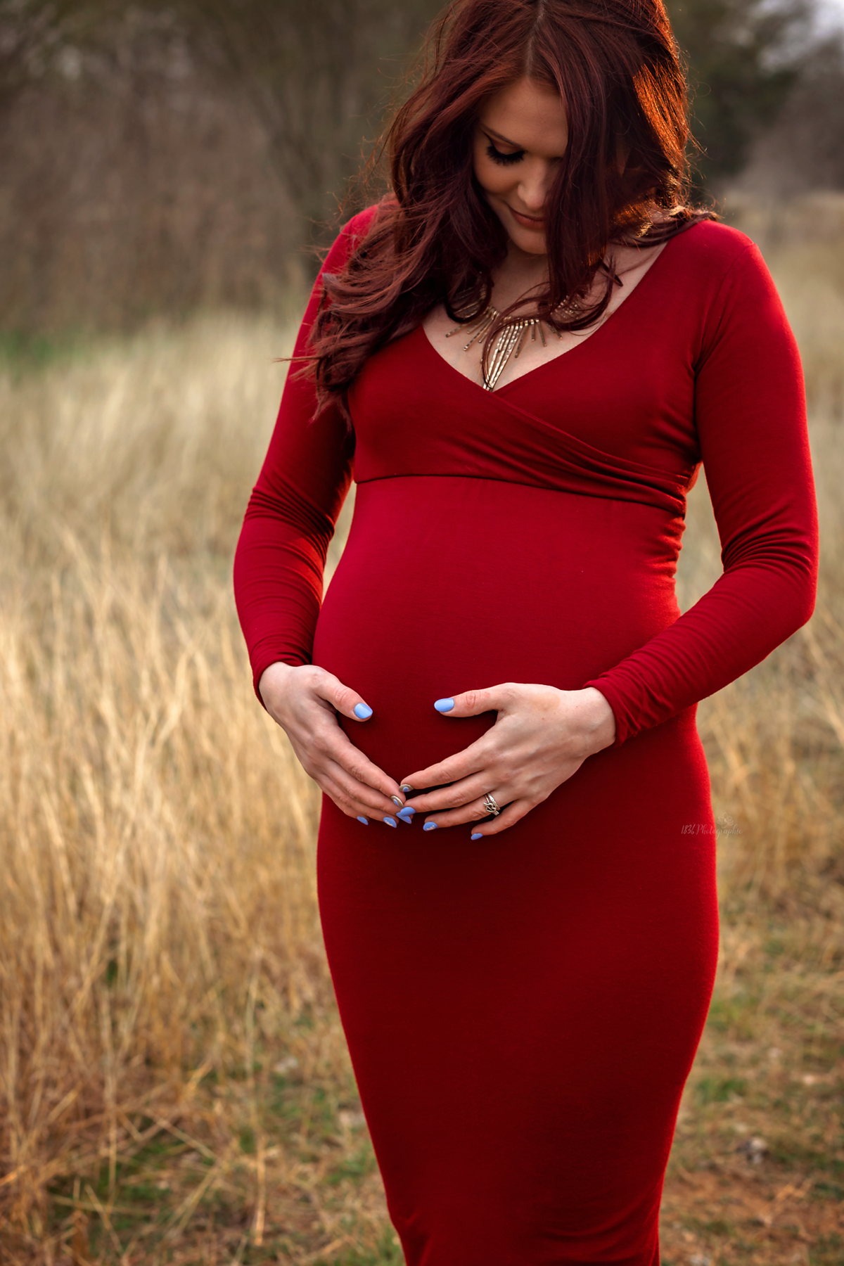 Discover chic elegance in a styled maternity session near San Antonio. Our mom-to-be, in a scarlet flying dress, adds a touch of sophistication to your family's winter portraits.