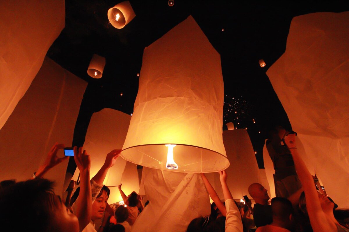 A breathtaking scene from the Yi Peng Lantern Festival in Thailand, where people release glowing paper lanterns into the night sky.