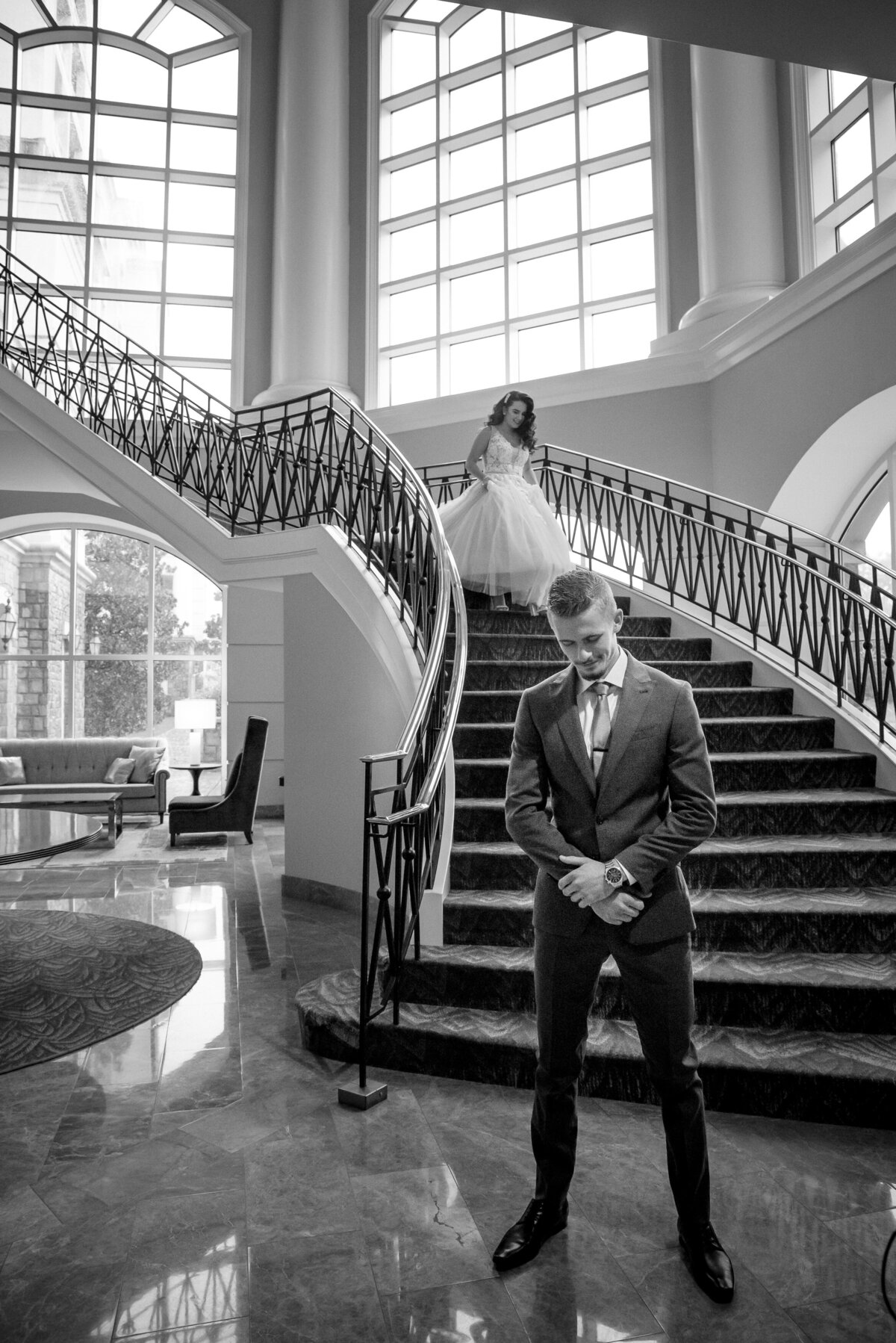 Bride descending staircase for first look at the Ballantyne Hotel by Charlotte wedding photographer DeLong Photography