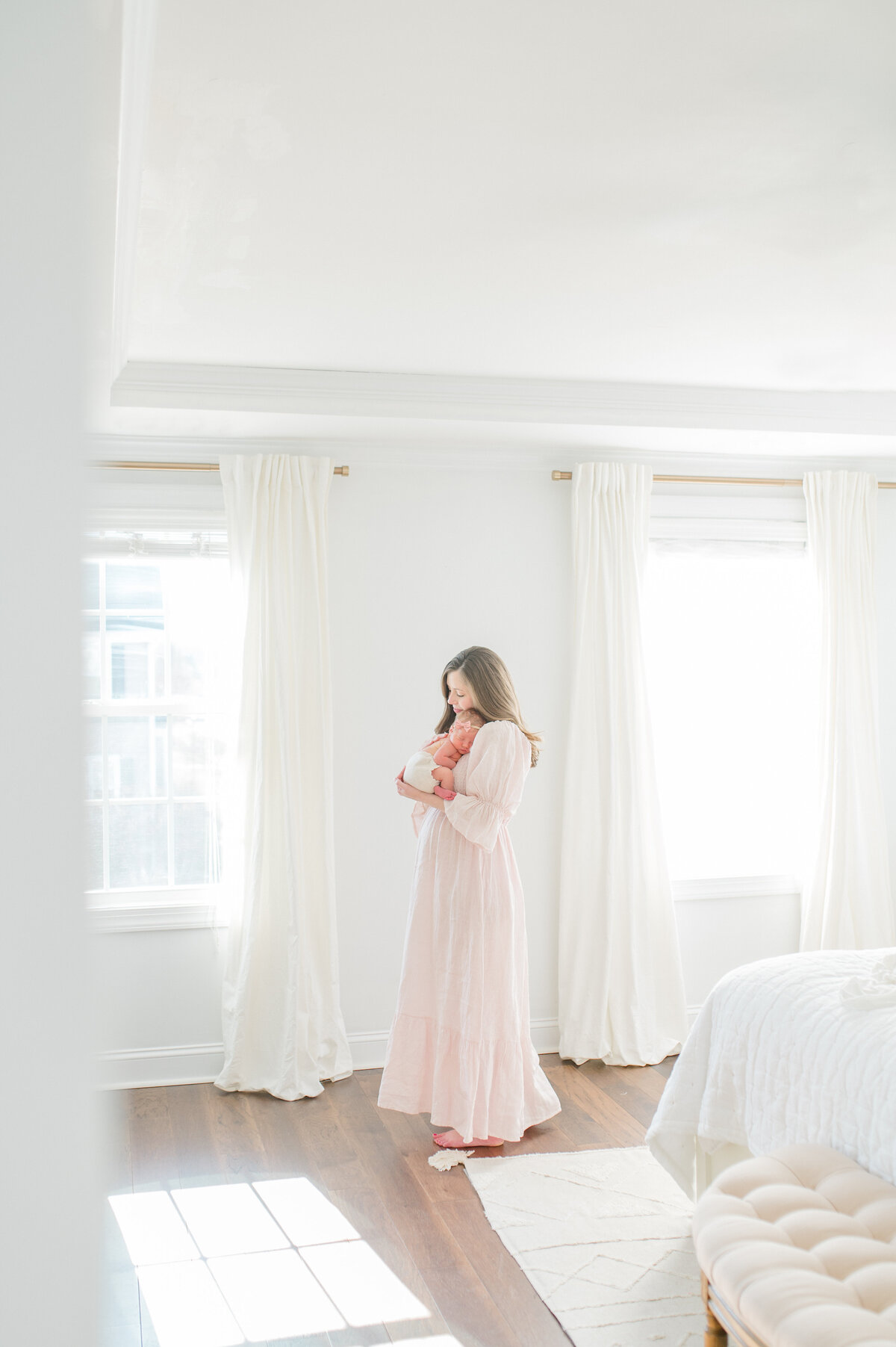 mom-holding-baby-girl-in-white-studio