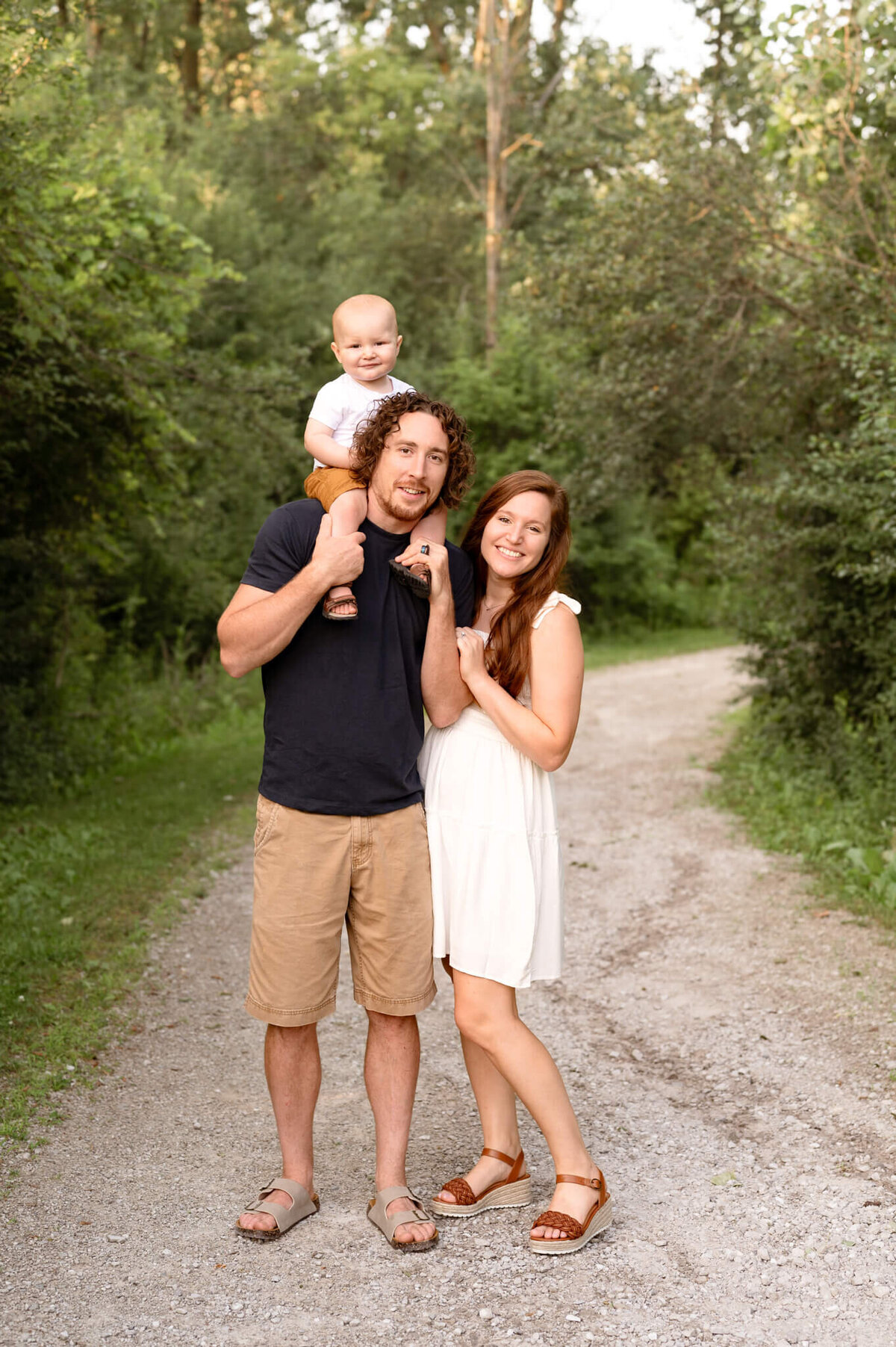 family posing for photos with toddler on dad's shoulders