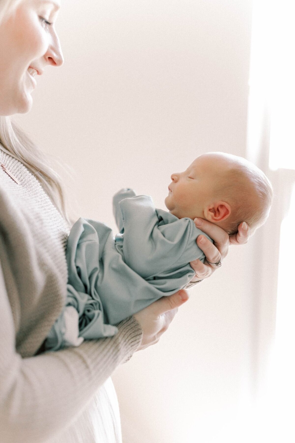 Mother holds baby in arms for Newborn Photography Alexandria session.