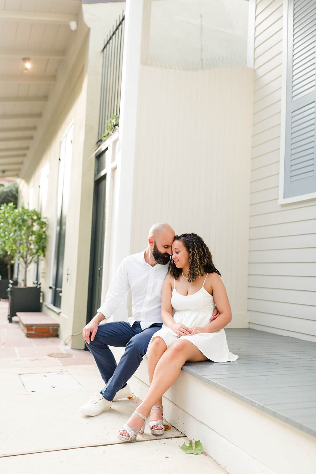 Engagement portrait of couple sitting on porch in New Orleans, Louisiana