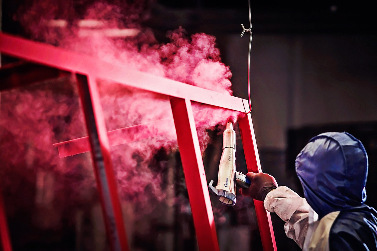 Advertising photograph of a worker in  a powder coating shop