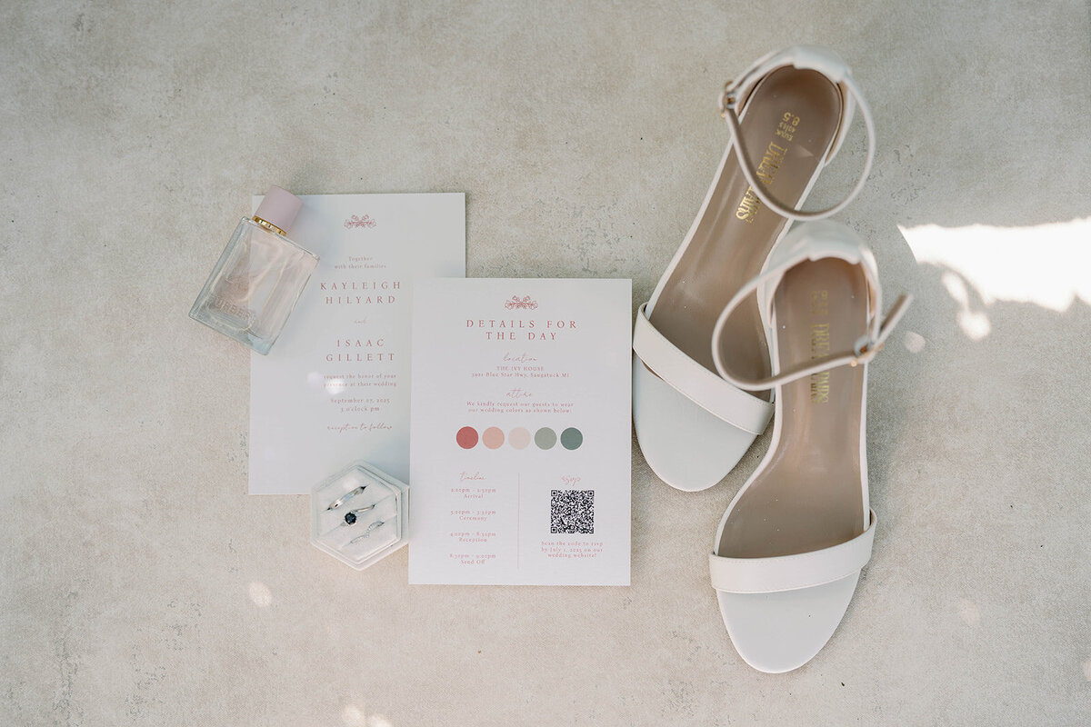 Flatlay detail shot of the wedding shoes, paper goods and rings styled for an Ivy House wedding.