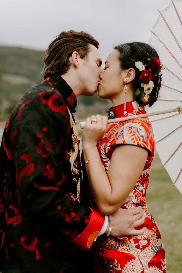 Bride and groom share a kiss at an outdoor Asian Fusion wedding