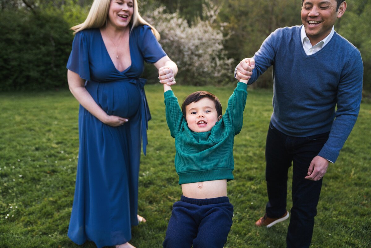 Playful photo of parents swinging toddler at Luther Burbank Park