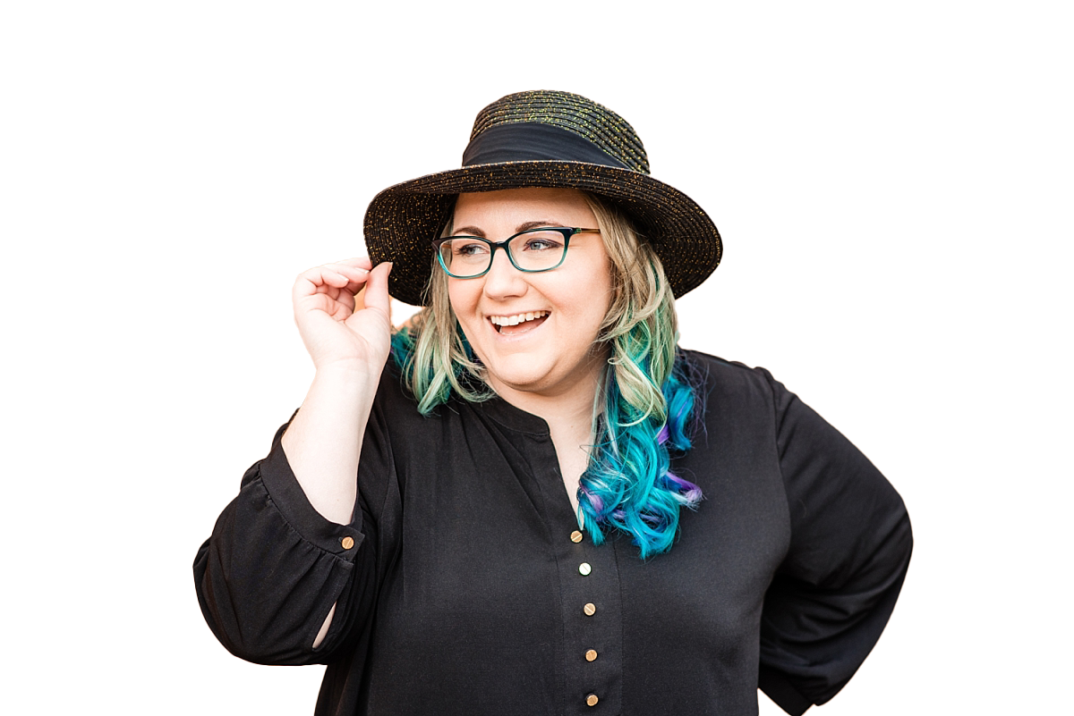 College senior portrait photographer wearing hate and smiling