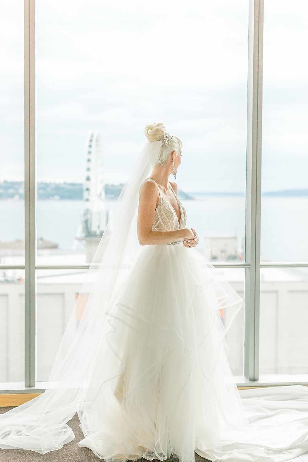 Four seasons Seattle bride in front of window with ferris wheel in background