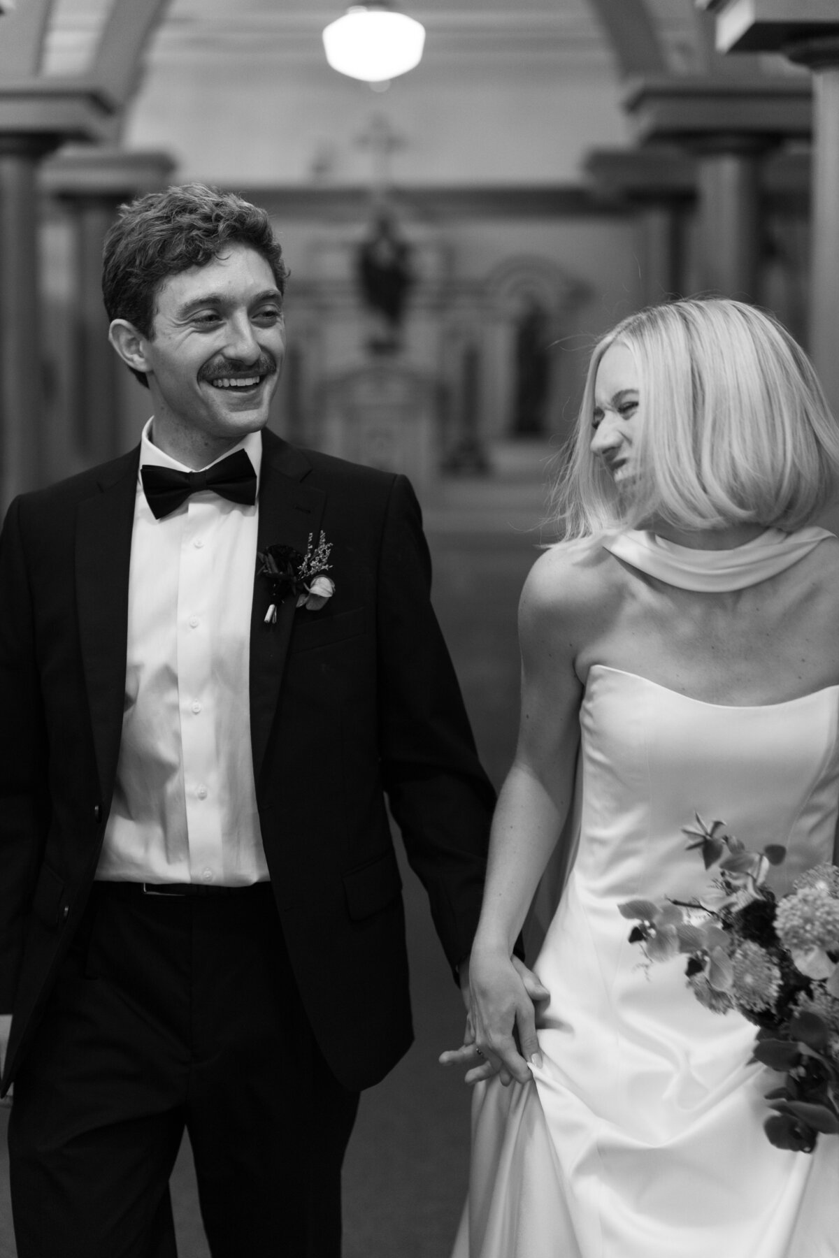 Bride and groom walking hand in hand smiling after wedding ceremony