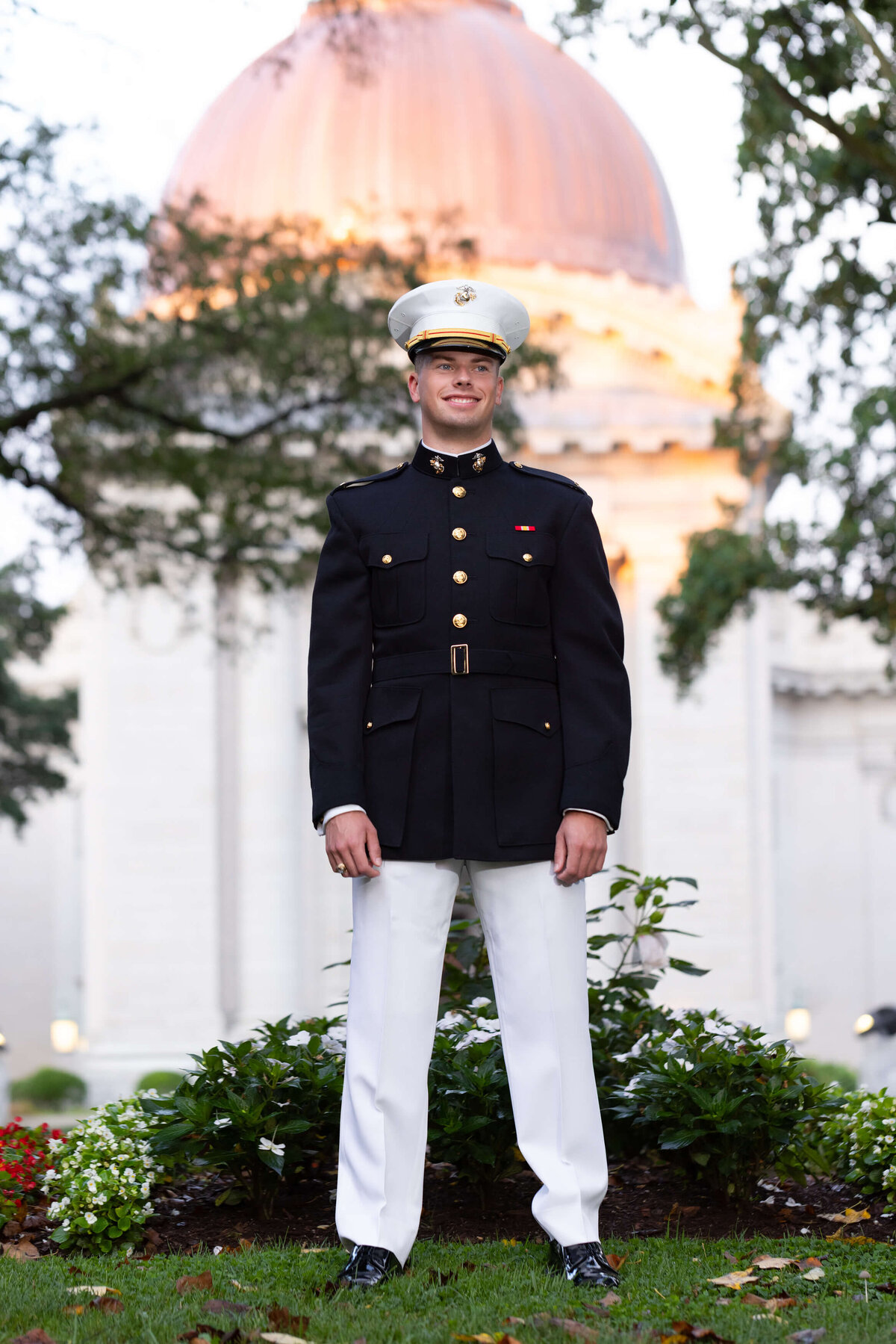 Senior Portrait in Annapolis Maryland of Midshipman inMarine Uniform at Naval Academy Chapel dome with flowers.