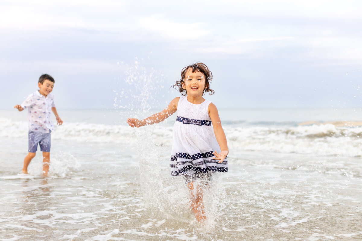 Two kids playing in the ocean during a family session in Jacksonville, FL