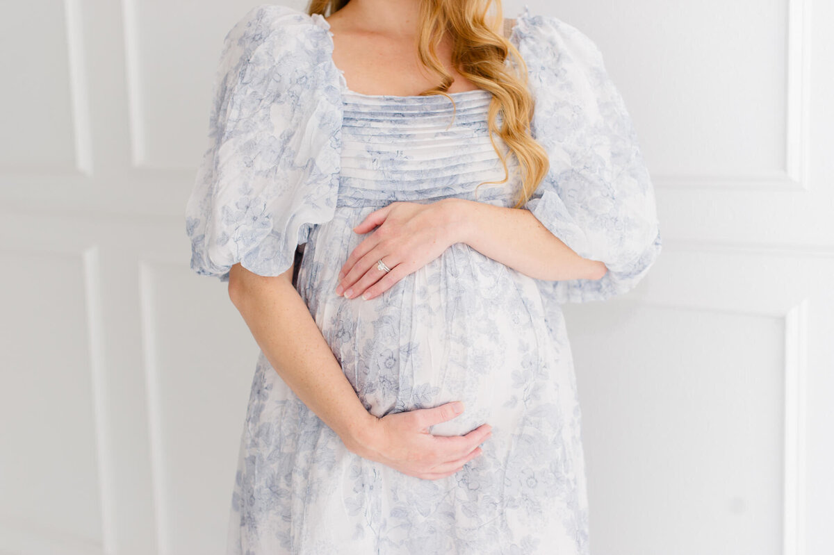 Closeup studio image of pregnant mom holding her belly during her Orlando maternity photographer photoshoot