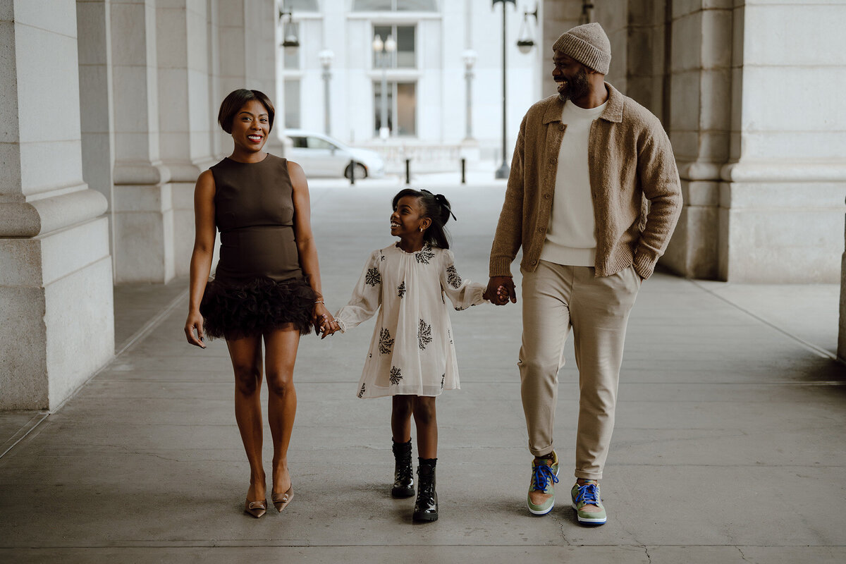 Family holding hands and walking towards the camera 