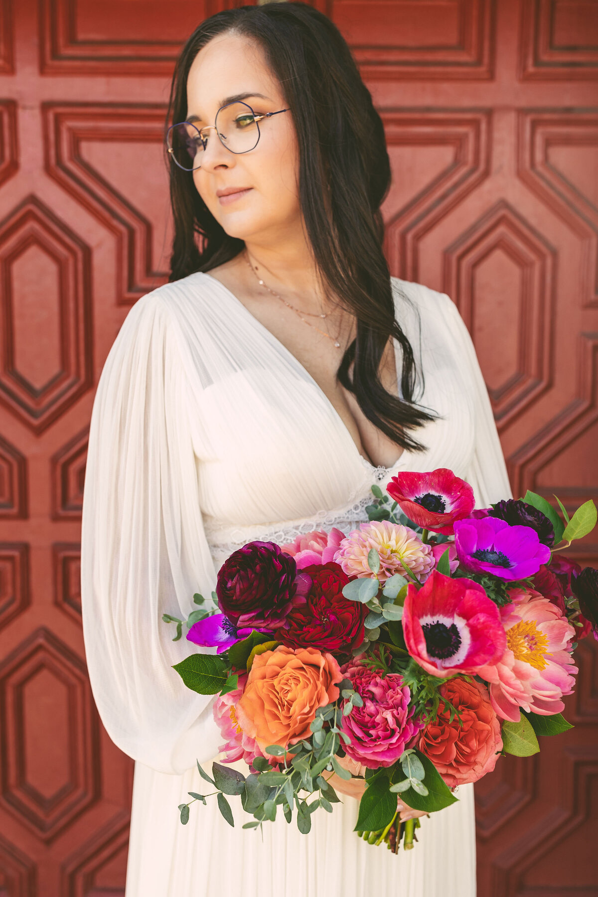 Wedding Day Bridal portrait in front of a red door with colorful flowers