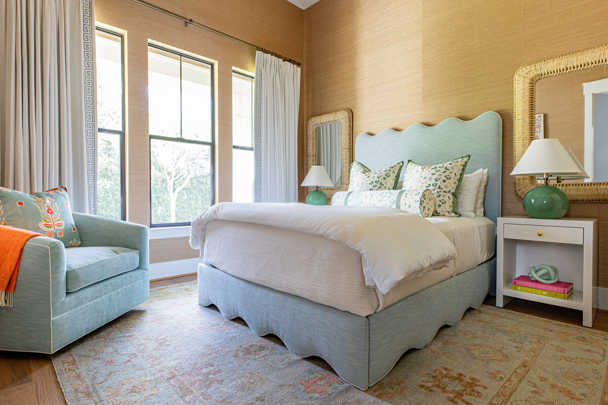 oyster creek studios aryns room light blue bed and chair in light brown bedroom
