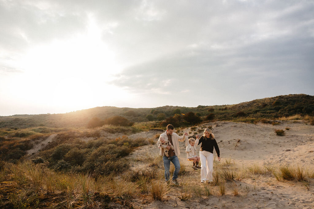 Gezinsfotoshoot in de duinen van Wassenaar met ouders en twee jonge kinderen in warm, natuurlijk licht door Linda Photography