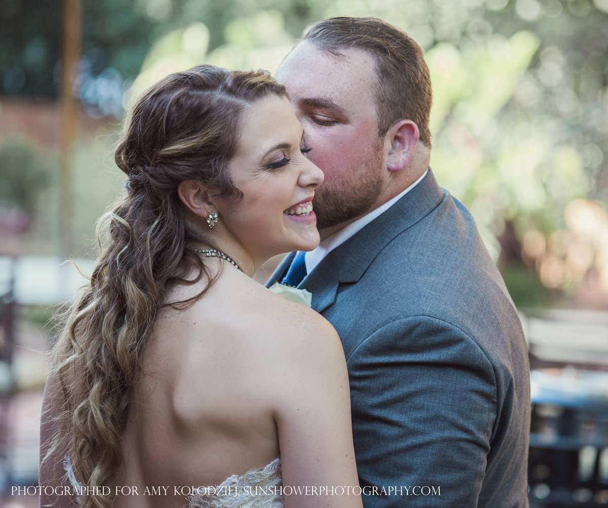 charlotte wedding photographer jamie lucido captures a fun moment with the bride smiling and groom kissing her