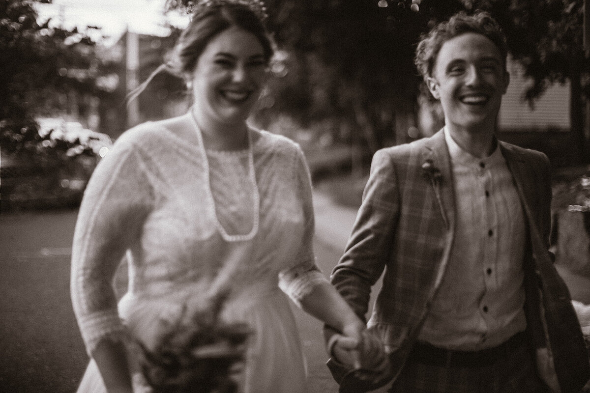 bride and groom excitedly run towards camera 