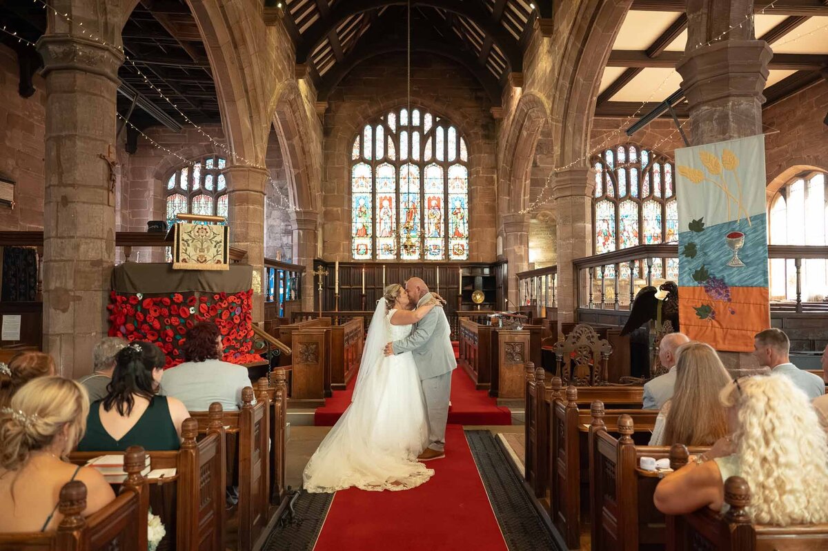 Bride and groom's first kiss at St Mary’s Church wedding ceremony in Northwich