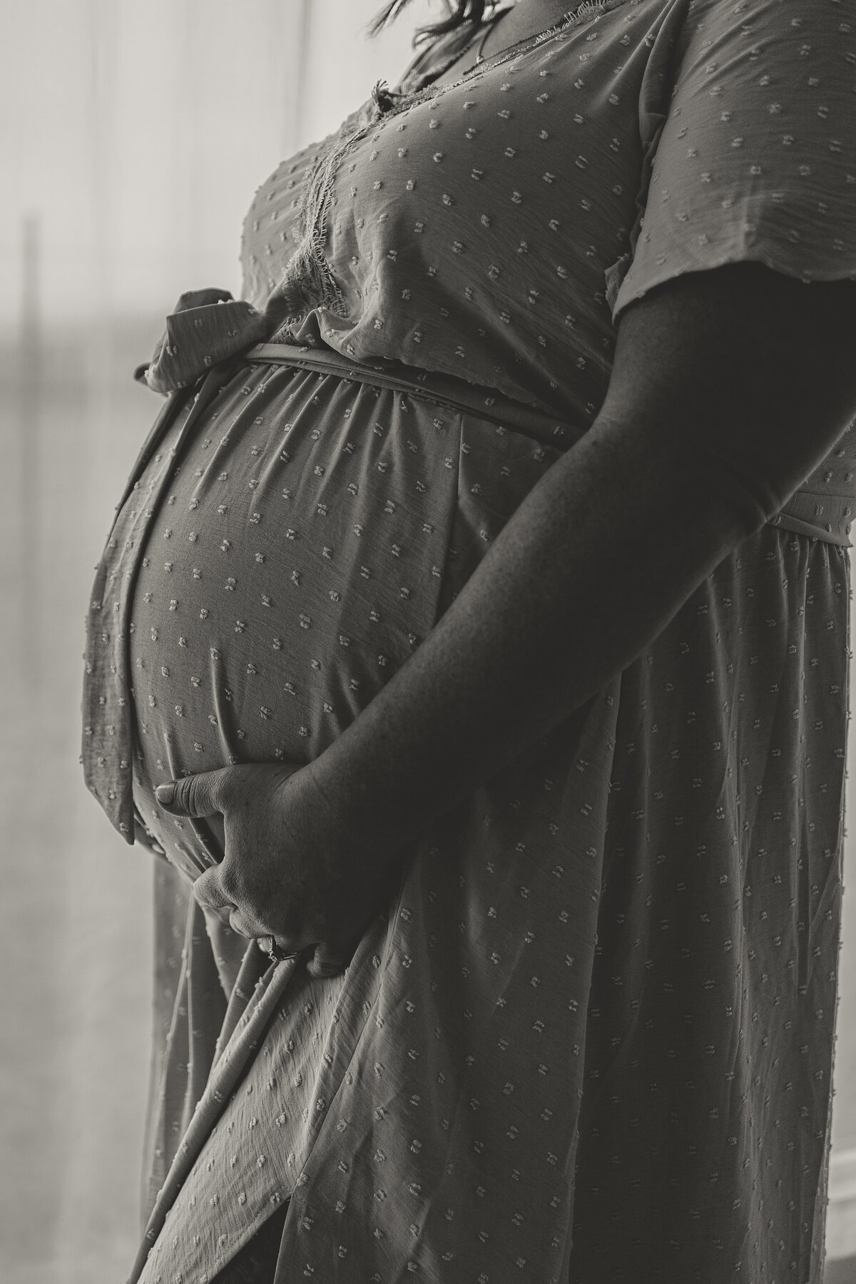 black and white image of just expectant mom of twin girls' pregnant belly during maternity session with alexis adkins photography in longmont colorado