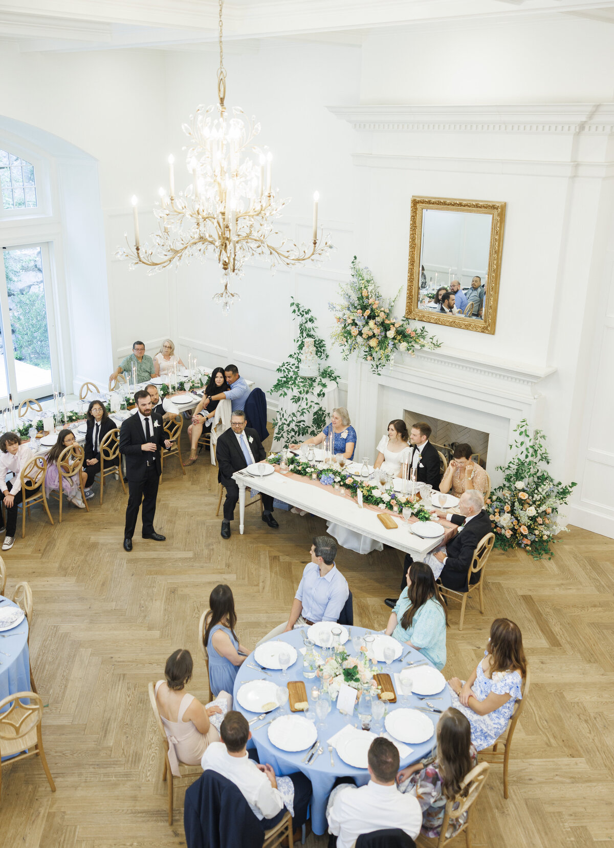 Detail view of a wedding reception at Twenty and Creek, with floral arrangements around the sweetheart table and fireplace