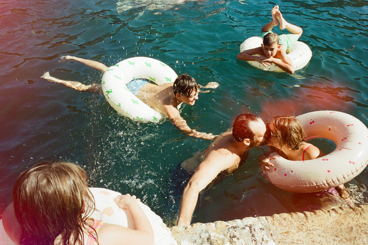 Toddler wearing undies  lying on top of mother with abstract art behind them