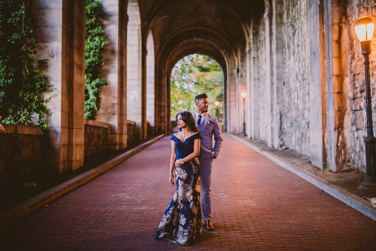 A couple in formal clothing during their engagement session standing inside the billings tunnel at fort tryon park nyc