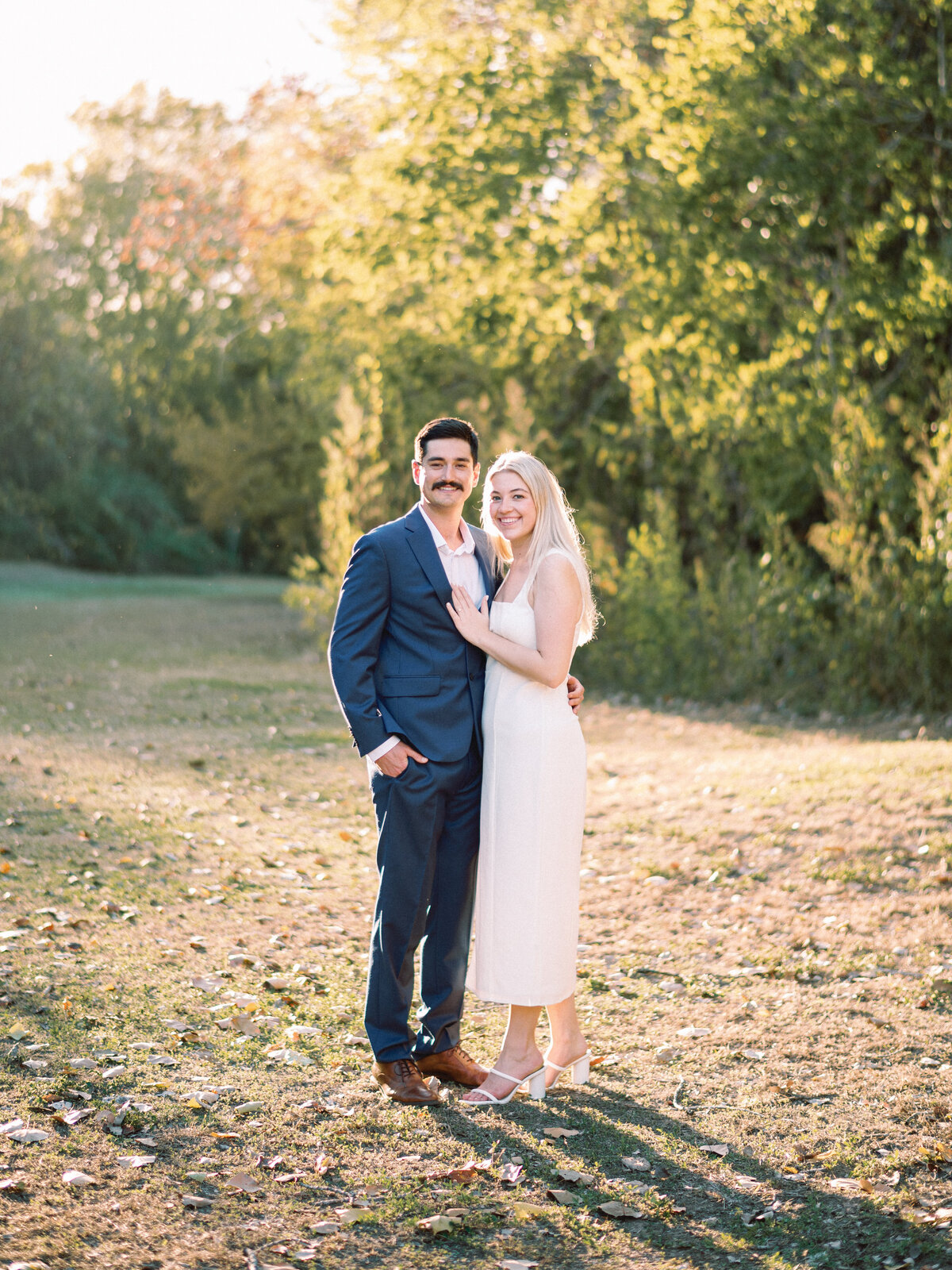 bride in white and groom in blue suit with golden hour sunlight portraits
