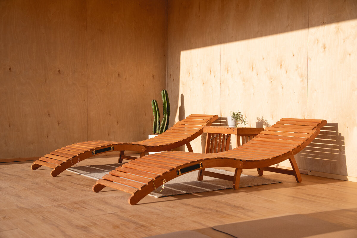 two-wooden-lounge-chairs-in-the-sun