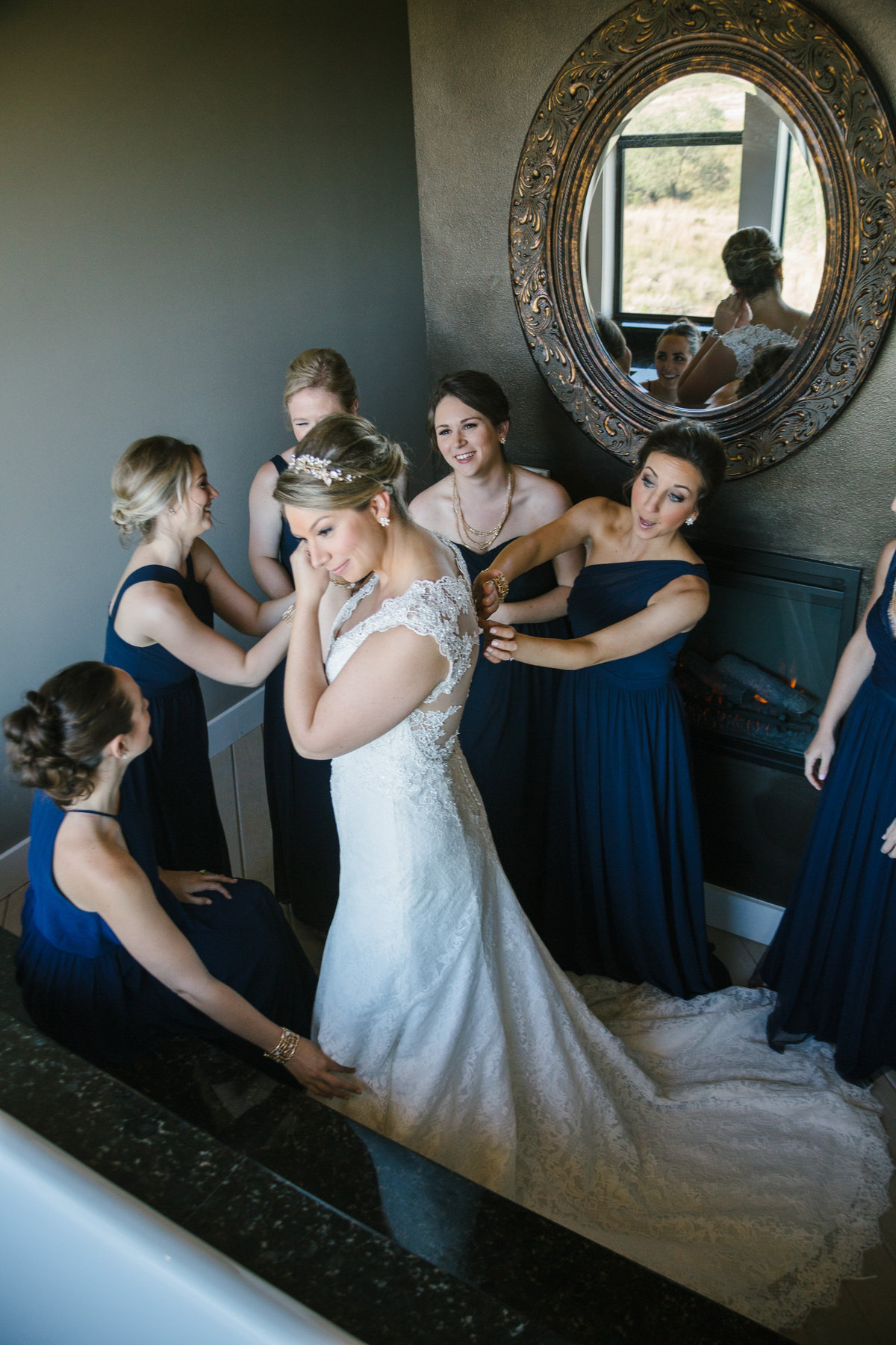 Bride Getting ready at Paniolo Ranch with all her bridesmaids surrounding her just before wedding ceremony.