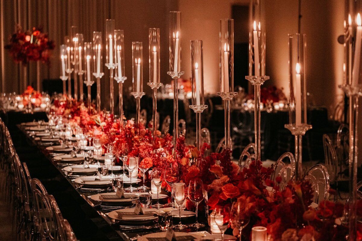 long wedding reception dinner tables with clear crystal candelabras and red flowers by Philadelphia wedding florist Sebesta Design