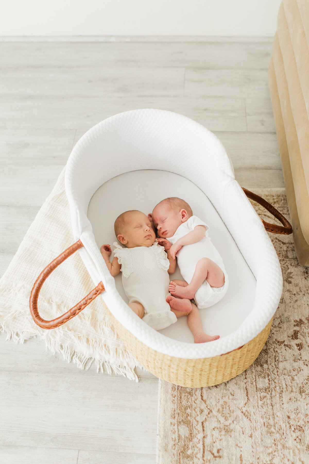 Twin newborns sleeping in a basket