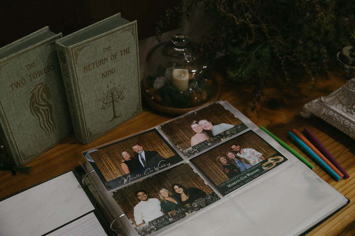 Wedding details including a Return of the King book, photo album and candle, representing the aesthetic of the client.