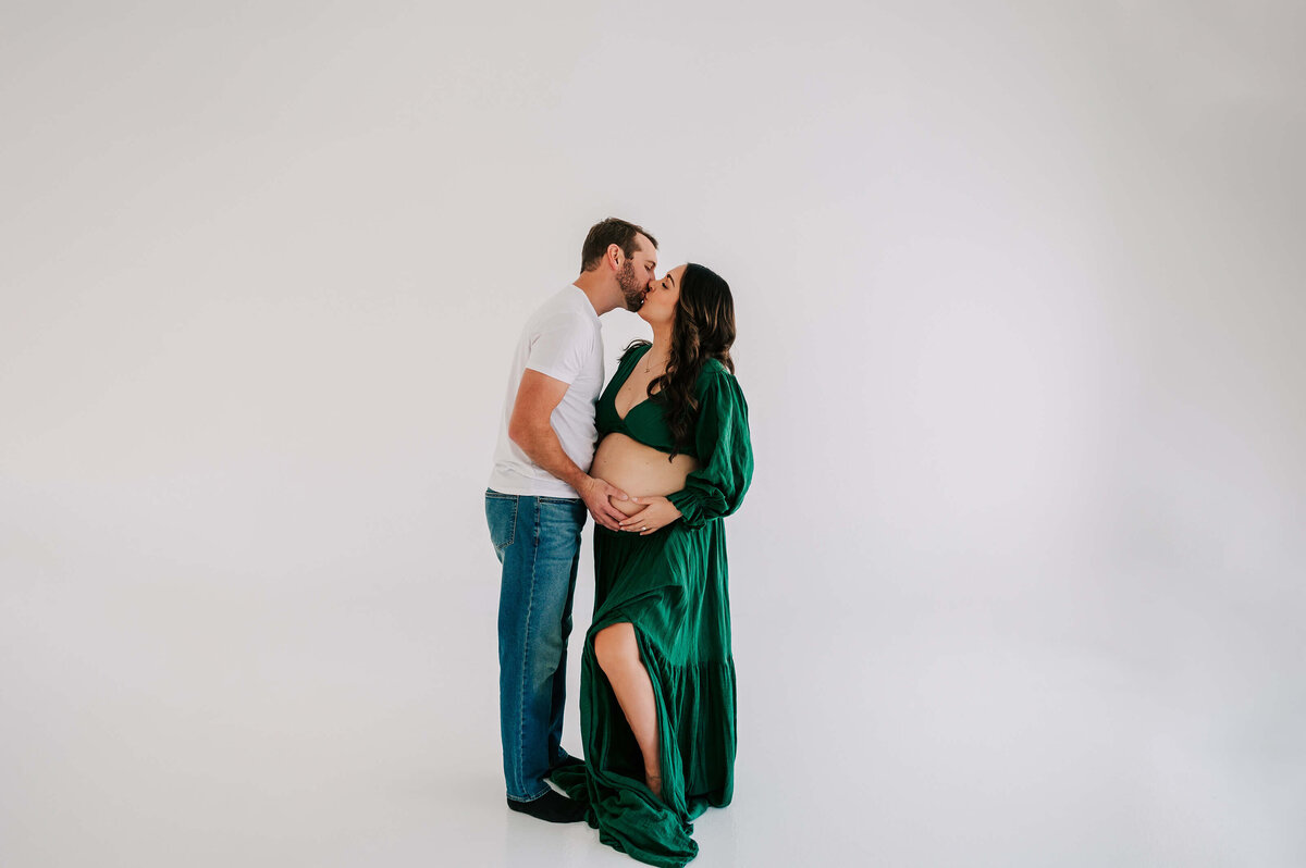 pregnant couple kissing in maternity photography studio in Joplin MO
