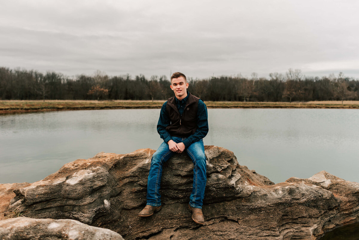 Branson Missouri senior photographer captures high school senior boy sitting on rock