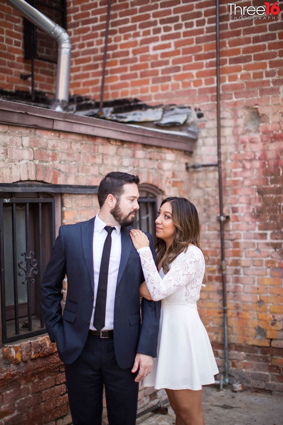 Engaged couple gaze at each other in the back alley in Old Towne Orange